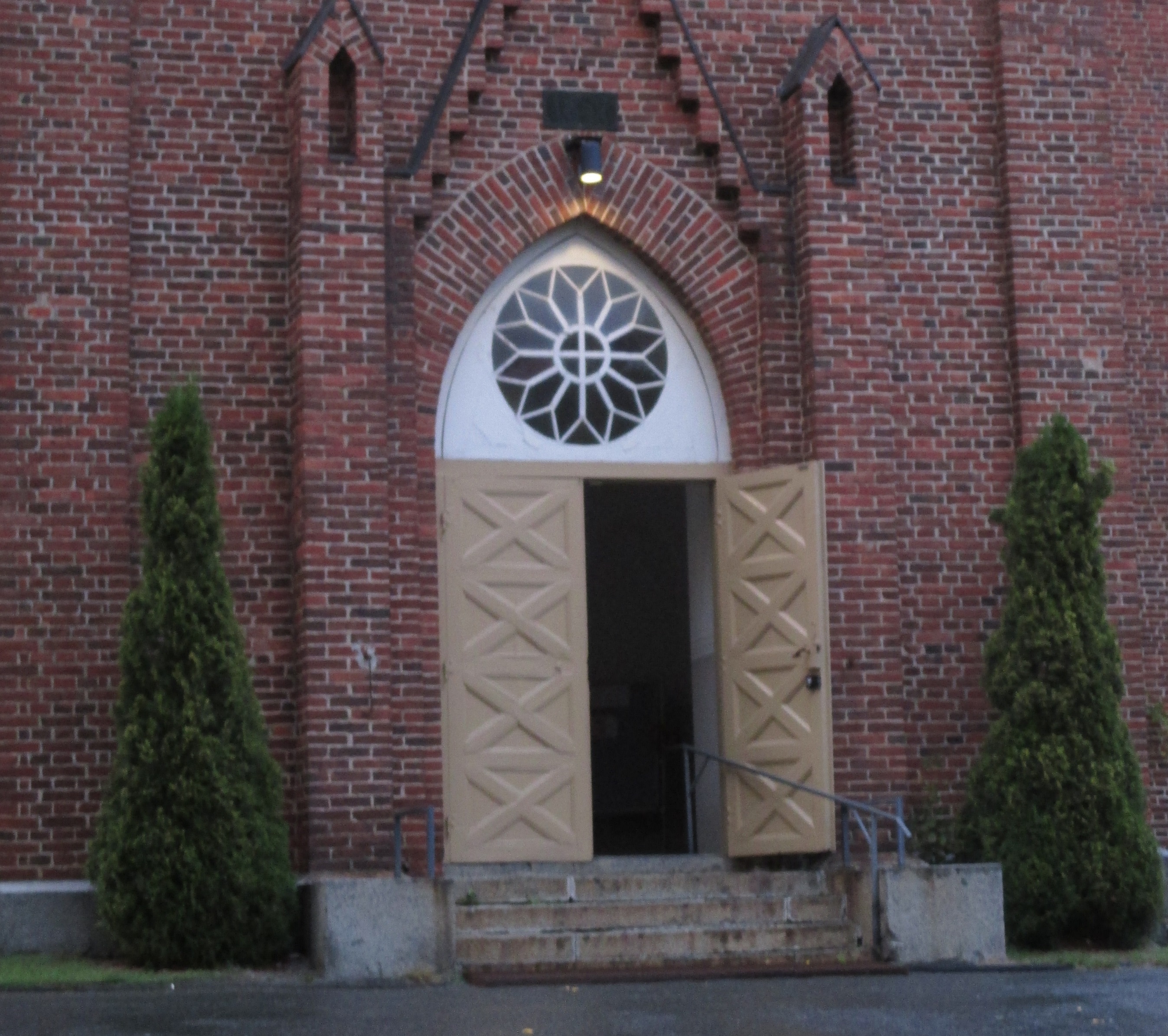 Kirkon avoin ovi ja tiiliseinää