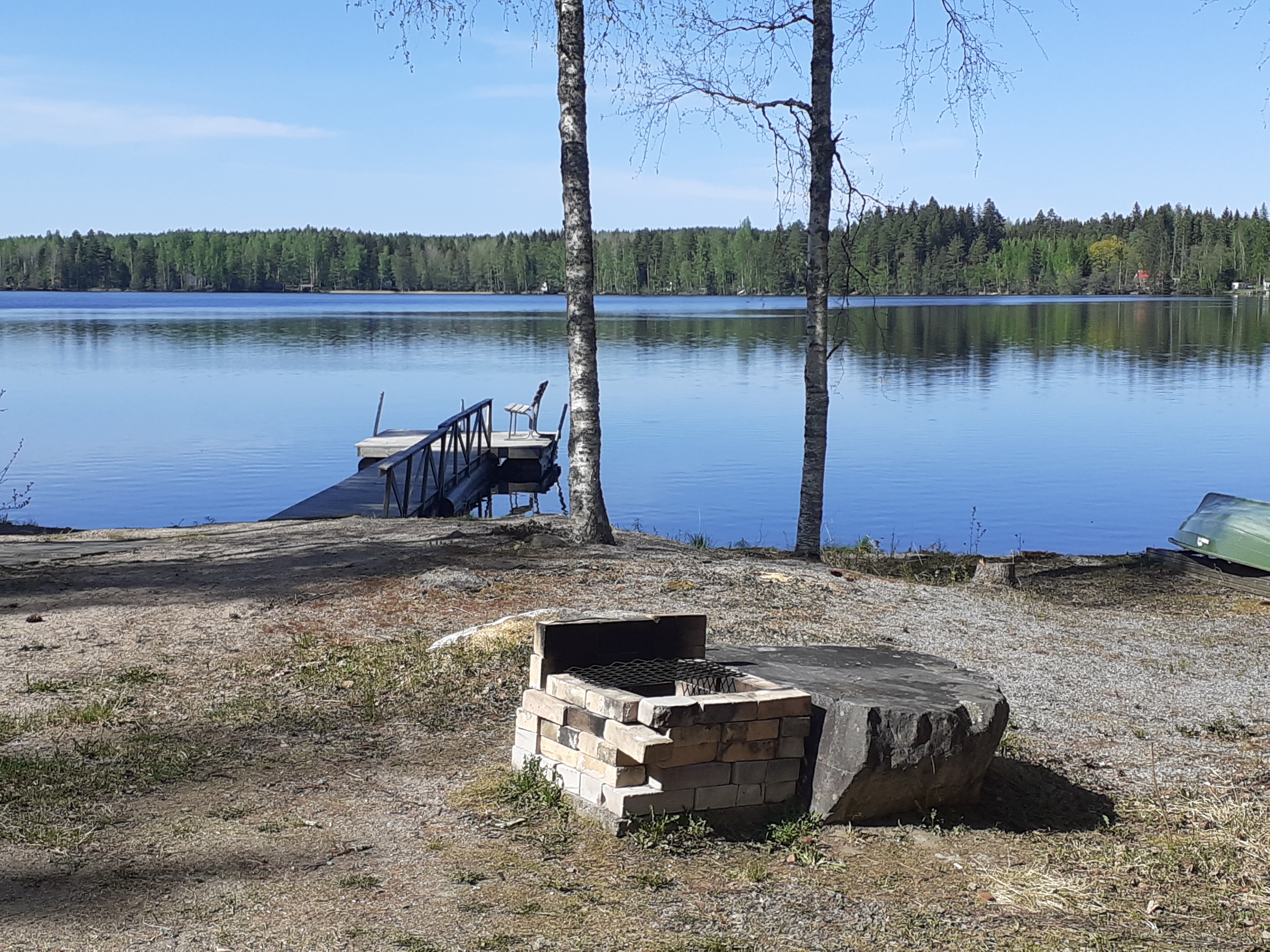 Tömäjärvi aurinkoisena kevätpäivänä, etualalla grilli ja laituri