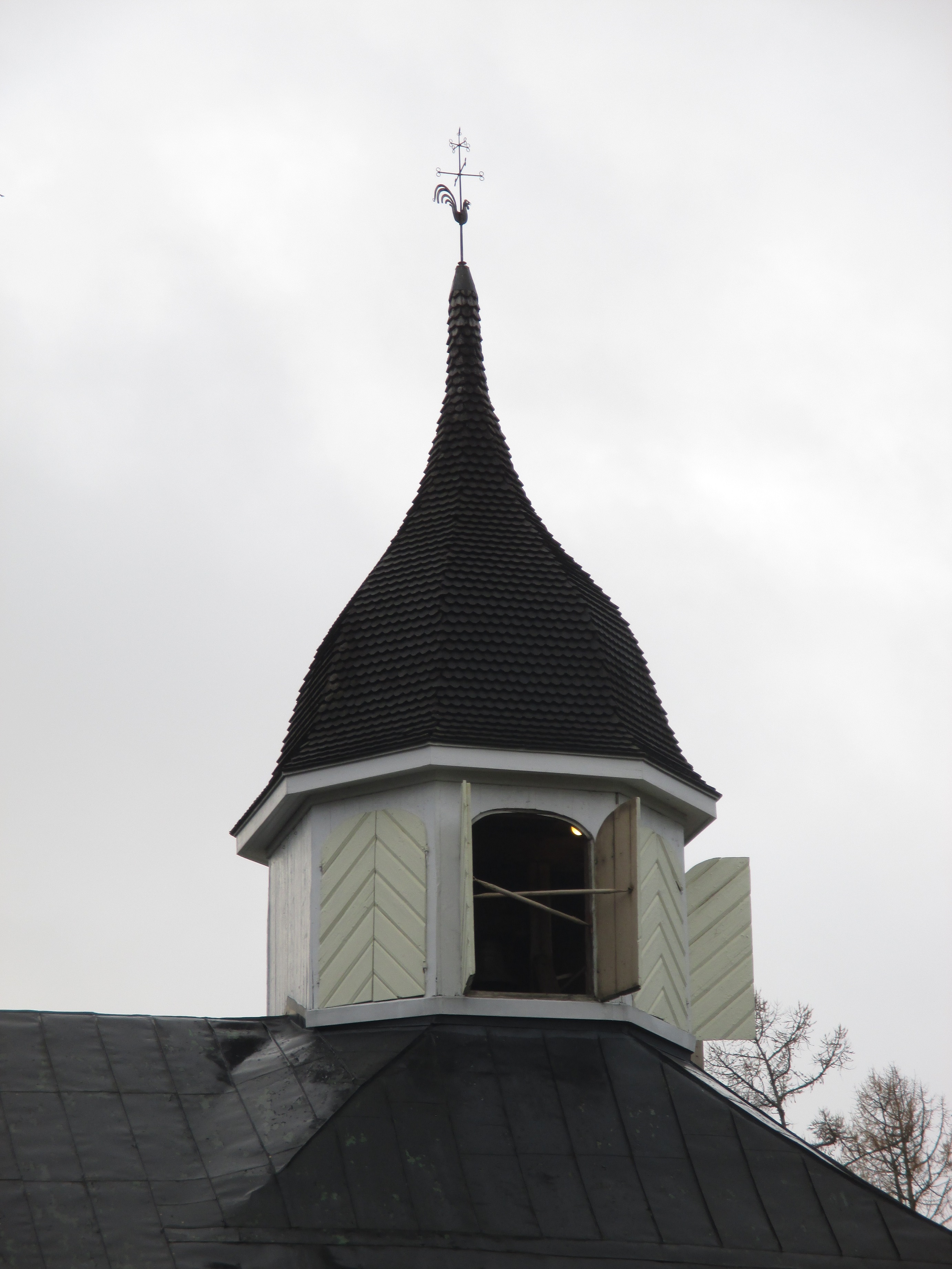 puurakenteisen kirkon kellotorni, jonka luukkuja on avattu