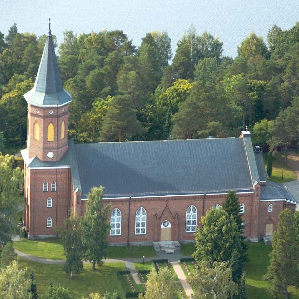 Hattulan kirkko yläviistosta kuvattuna, vehreiden puiden ympäröimänä